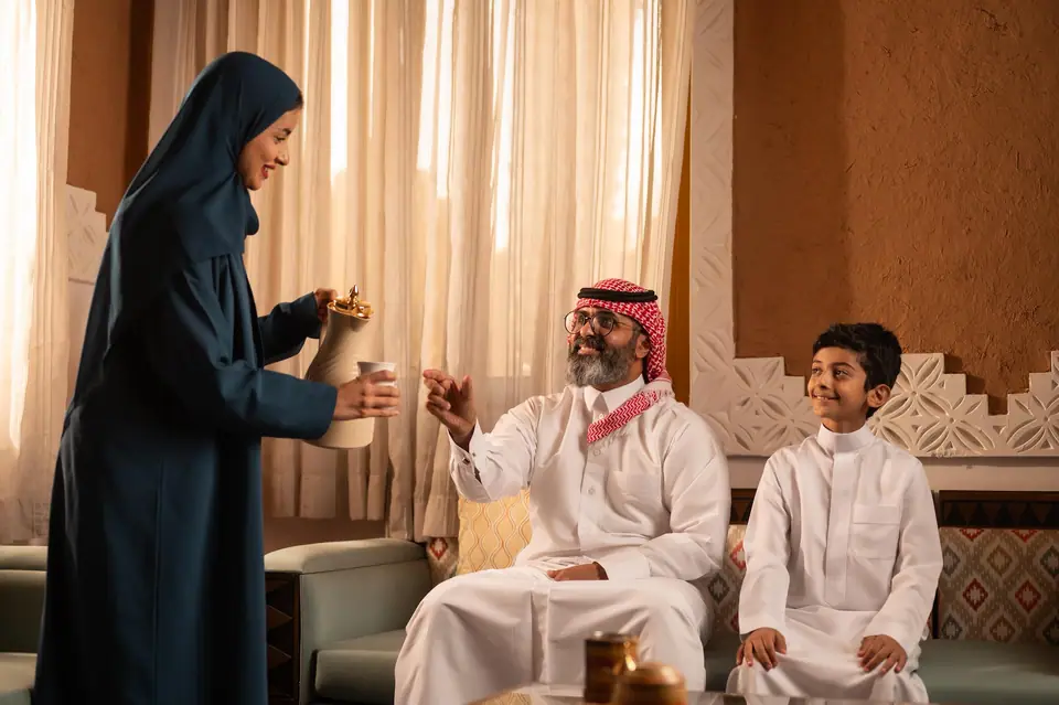 A family enjoying Arabic coffee in the majlis of a Najd Heritage villa